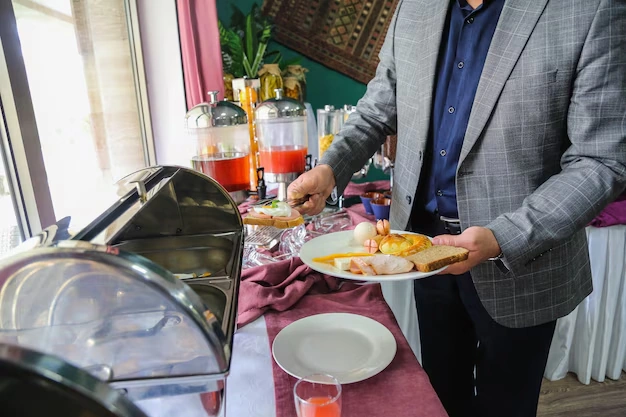 man-serving-himself-breakfast-from-buffet-with-plate