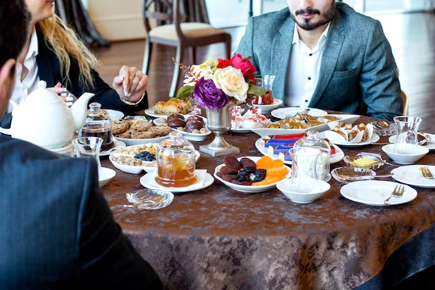 people-enjoying-tea-and-snacks-at-table-with-desserts