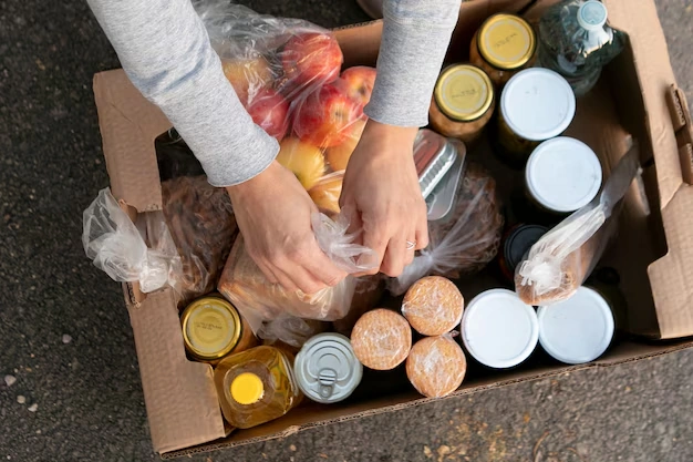 person-packing-food-items-into-box